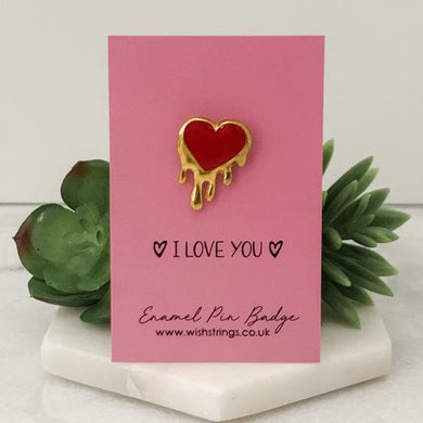 pink card with I love you pin badge some succulent plants in the background.